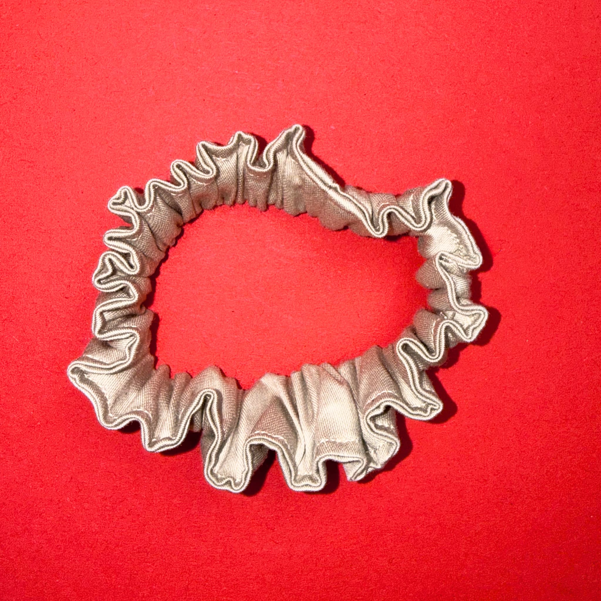 Detail řasení Scrunchie Mini béžově zlatá od Hecatoo™,  bavlněný satén s jemným zlatavým leskem, bez polyesteru. Vyrobeno v EU, certifikováno Öko-Tex Standard 100 tř. I.