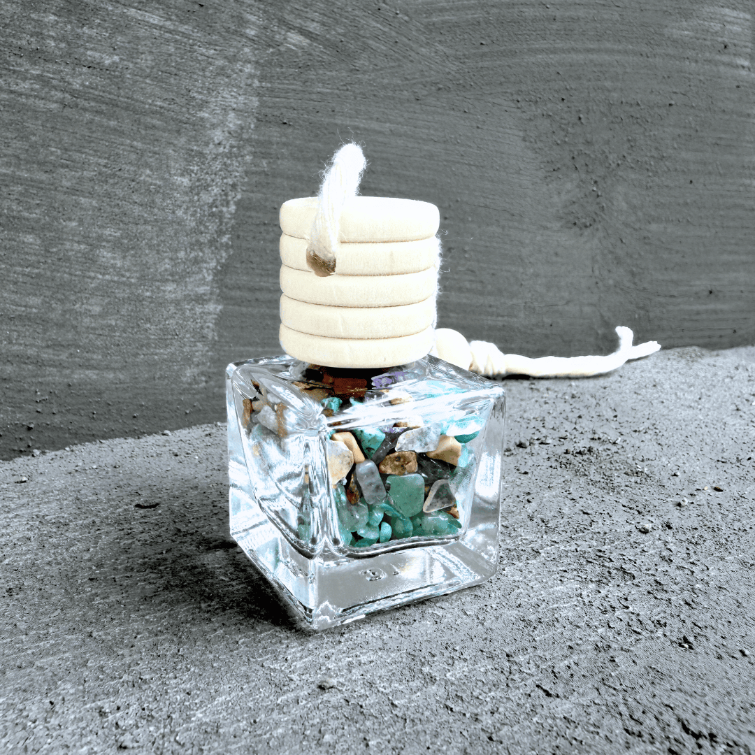 Detailní pohled na talisman Hecatoo pro kreativitu z minerálů lapis lazuli, aventurínu, labradoritu a ametystu ve skleněné lahvičce s dřevěným víčkem.